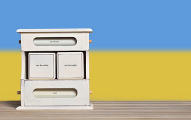 Fototapete - Wooden retro calendar with free space for a date on the background of the flag of Ukraine. Template for writing dates of national holidays of Ukraine with free text space