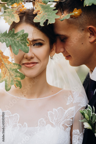 Cuadros en Lienzo Groom and Bride portrait with oak leaf before her face in autumn