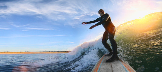 Mature senior adult surfing on a big wave in the ocean