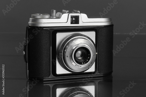 Fotografía Old retro photo camera on dark black table
