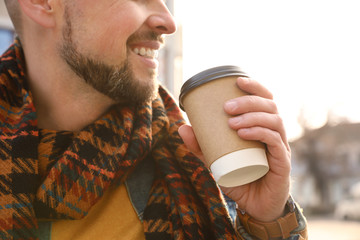 Wall Mural - Man with cup of coffee on city street in morning, closeup