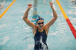 © primipil - Young woman swimmer portrait joy rejoices in victory in swimming competitions in swimming pool. Win concept.