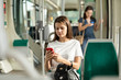 © JackF - Woman using mobile phone in the cabin of a bus or tram