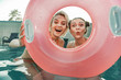 © Yakobchuk Olena - Cheerful girls looking at camera through inflatable ring