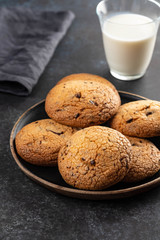 Wall Mural - Chocolate chip cookies with milk on black table. Copy space.