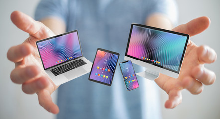 Wall Mural - Businessman connecting modern smartphone tablet laptop and computer 3D rendering