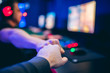 © Parilov - Professional gamer greeting and support team fists hands online game in neon color blur background. Soft focus, back view