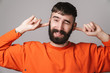 © Drobot Dean - Image of bearded man with nose jewelry smiling and plugging his ears