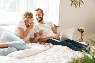 Wall Mural - beautiful young couple relaxing on bed
