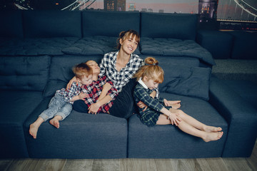 Wall Mural - Beautiful woman with child. Woman in a shirt. Family sitting on the couch.