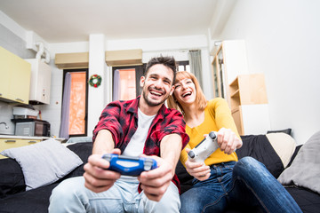 Portrait of happy excited couple playing video games.