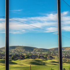 Wall Mural - Square Golf course and houses on a residential area with fence in the foreground