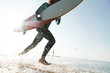 © Drobot Dean - Cropped photo of caucasian young man holding surfboard while running