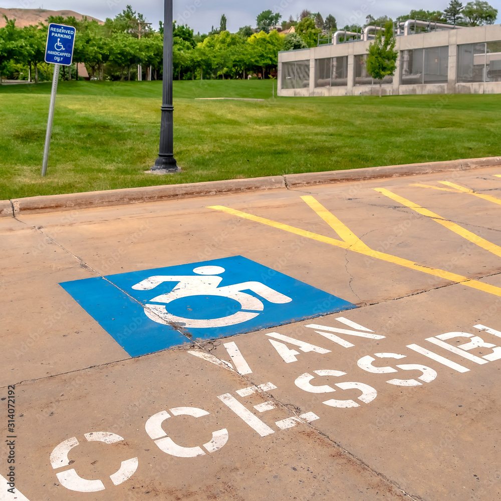 Square Handicapped parking lot with painted handicap symbol and Van Accessible sign