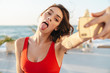 © Drobot Dean - Photo of young funny woman sticking out her tongue and taking selfie