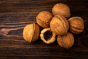 Wall Mural - Shortbread in shape nut with caramel on dark wooden background.