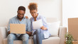 © Prostock-studio - Afro Spouses Using Laptop Reading Property Papers Sitting On Couch