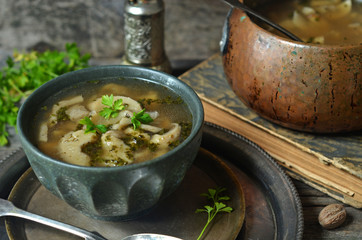 Oyster mushroom soup in a green bowl on a metal tray