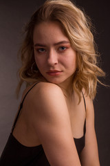  Studio portrait of blonde on a dark background in a dark dress