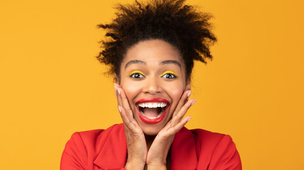 Wall Mural - Happy afro woman screaming and holding cheeks