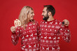 © ViDi Studio - Smiling young couple guy girl in Christmas knitted sweaters posing isolated on red wall background. Happy New Year 2020 celebration holiday party concept. Mock up copy space. Hold house bunch of keys.