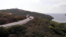 Car And Bus Driving Around Corner At Cape Sounion, Static Slow Motion Aerial