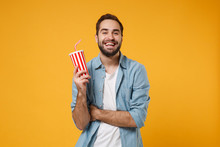 Funny Young Man In Casual Blue Shirt Posing Isolated On Yellow Orange Wall Background, Studio Portrait. People Sincere Emotions Lifestyle Concept. Mock Up Copy Space. Hold In Hand Cup Of Soda Or Cola.