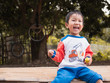 © Namphueng - Asian child boy laughing with happy funny face while playing bubbles outdoor with natural rural background. Young kid have fun in relaxing holiday.