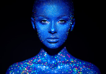 Fashion model woman in blue bright sparkles and neon lights posing in studio.  Portrait of beautiful sexy woman. Art design colorful glitter glowing make up