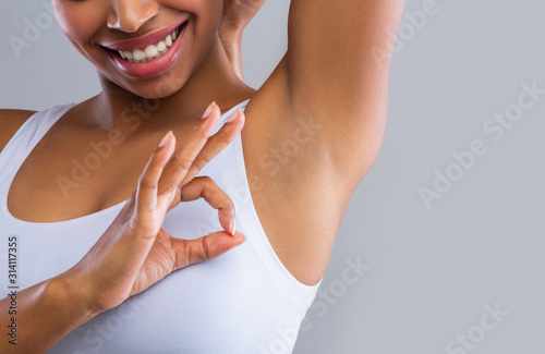 Fotografía Cropped of woman looking at shaved armpit, showing okay gesture