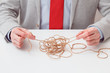 Alone businessman try to unwinds tangled thread ball like puzzle out situation. Conceptual photo.