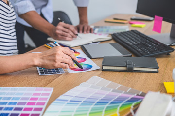 Poster - Two colleagues creative graphic designer working on color selection and drawing on graphics tablet at workplace, Color swatch samples chart for selection coloring
