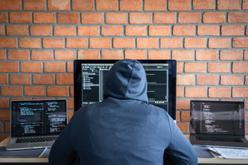Leinwandbilder - Computer hacker or cyber attack concept, Dangerous hooded hacker using multiple computers typing bad data into online system the access with a virus to infect steal information