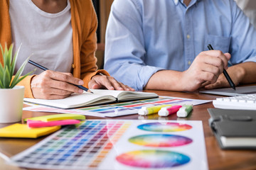 Poster - Two colleagues creative graphic designer working on color selection and drawing on graphics tablet at workplace