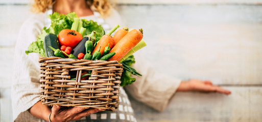 Caucasian woman people with bucket full of coloured and mixed fresh healthy food like fruit and vegetables - concept of little store with km 0 products