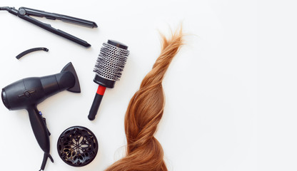 Set of tools dryer, iron and hair brush for hairstyle and red hair on white