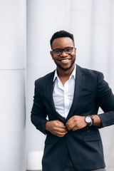 Portrait of a smiling young african american .guy in a stylish formal suit, outdoors