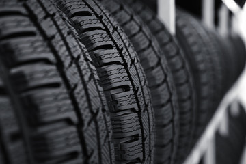 Car tires on rack in auto store, closeup