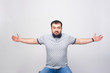A man warmly greets the viewer with his arms spread wide over a white background.