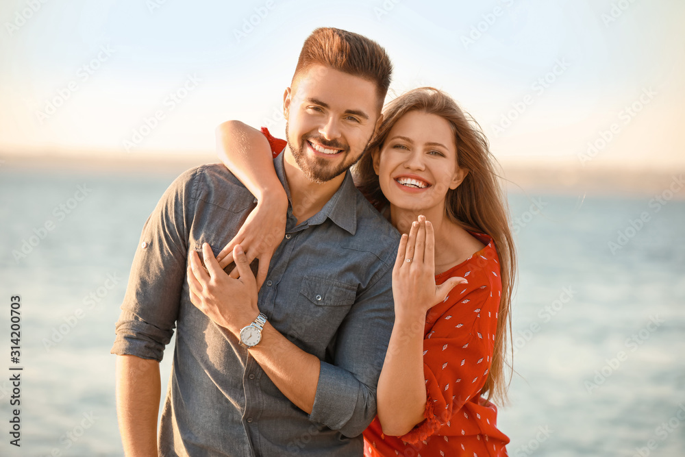 Happy engaged couple near river
