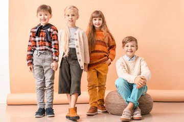 Sticker - Cute little children in autumn clothes near color wall