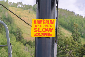 Wall Mural - Safety sign on a chairlift against trails and mountain landscape at off season