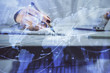 © peshkova - Double exposure of woman's hands making notes with forex graph hologram. Concept technical analysis.