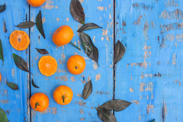 Wall Mural - Fresh mandarin oranges fruit or tangerines with leaves on wooden table, copy space