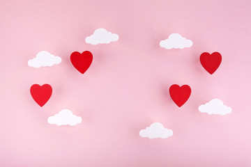 Valentine's day background. Red hearts and clouds on soft pink background feel like fluffy in the air