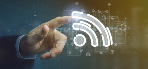 Poster - Businessman holding a wifi icon with data all around