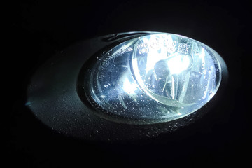 The xenon lamp in car's headlight glows.