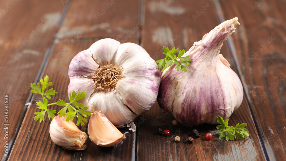 garlic clove and bulb on wood background - obrazy, fototapety, plakaty 