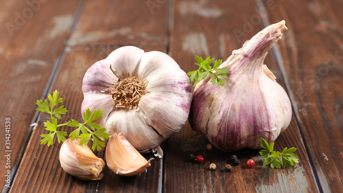 Cuadros en Lienzo garlic clove and bulb on wood background