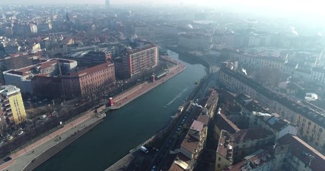 Wall Mural - Aerial view of Milan (Italy) in winter day with haze. Flying forward over the Milano Darsena Navigli district. The Darsena (the ancient dock of Milan) was redeveloped in 2015.